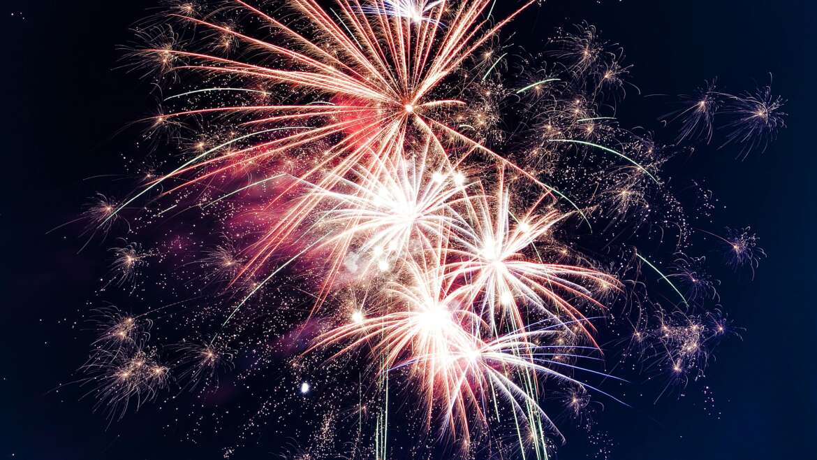 Colorful fireworks exploding in the night sky creating a festive atmosphere.